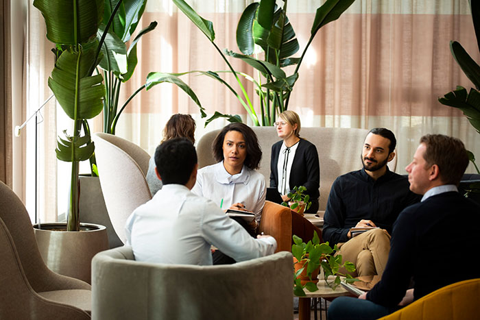 En grupp människor sitter i en modern och färgglad lounge.